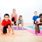 Kids doing yoga in a gym