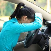 girl leaning against steering wheel in car