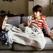 little boy sitting on couch drinking from a straw-featured