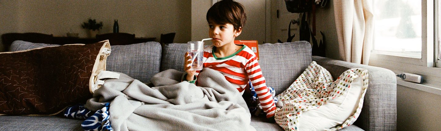 little boy sitting on couch drinking from a straw-featured