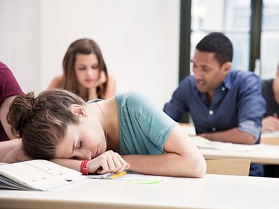 teenager asleep on her desk at schoo