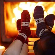 Man and woman in warm socks near fireplace