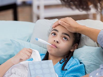 Concerned mother checks her daughter's temperature