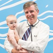 Cardiologist Gerard Martin holding a baby