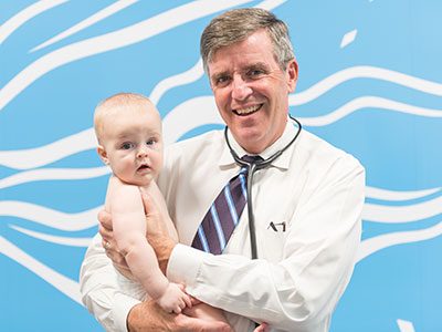 Cardiologist Gerard Martin holding a baby