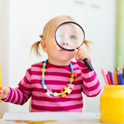 Toddler girl looking through magnifier