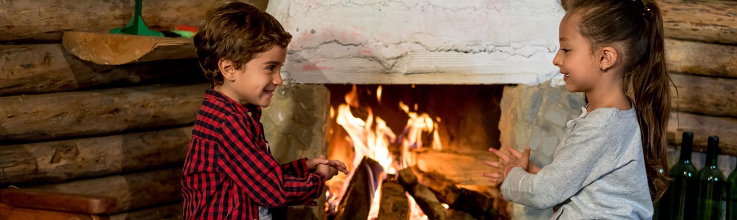 boy and girl sitting by fireplace