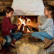 boy and girl sitting by fireplace