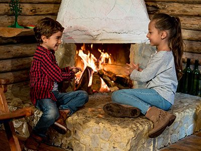 boy and girl sitting by fireplace