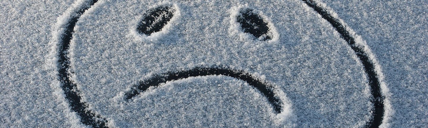 frowny face drawn in the snow