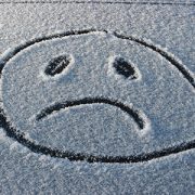 frowny face drawn in the snow