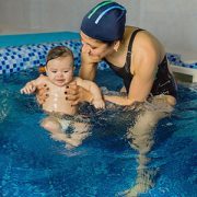 woman teaching baby to swim