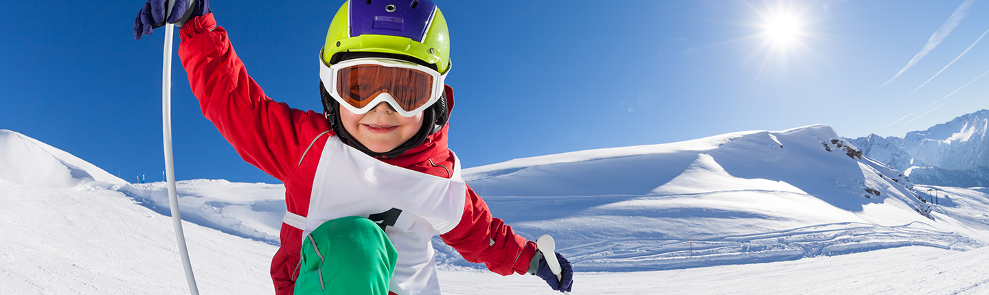 Little skier having fun at sunny snowy day