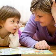 Mom and kid lying on floor reading book