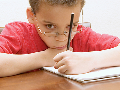 sad looking kid with pencil