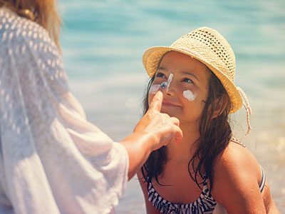 mother applying sunscreen to daughter's face