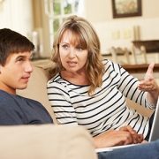 Mother And Teenage Son Arguing On Sofa