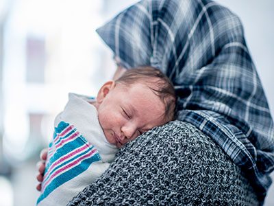 baby sleeping on woman's shoulder