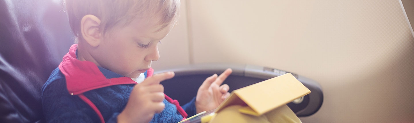 little boy using tablet on plane