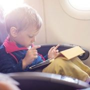 little boy using tablet on plane