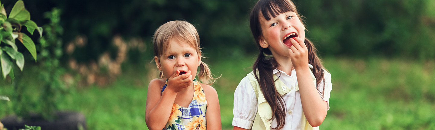 two girls eating cherries