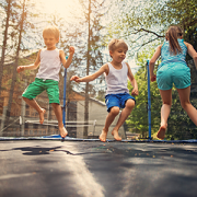 Three kids jumping on large trampoline