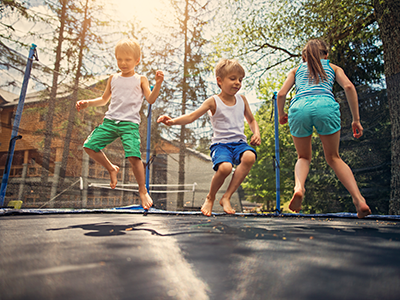 Three kids jumping on large trampoline