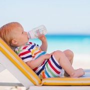baby drinking from bottle on the beach