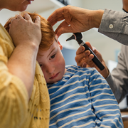 boy getting his ear examined by doctor