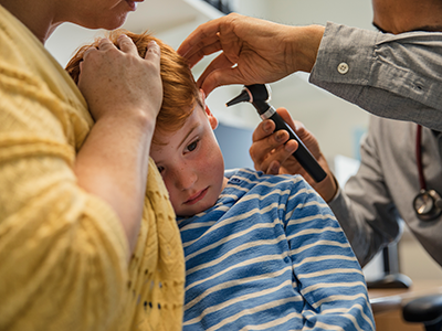 boy getting his ear examined by doctor