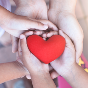 Red heart in child and parent hands