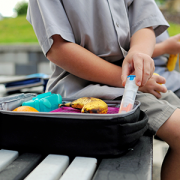 child reaching into lunch box for epi pen
