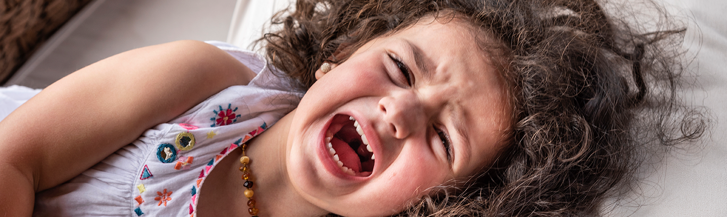 little girl having a tantrum in bed