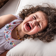 little girl having a tantrum in bed