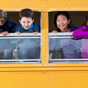 Children looking out school bus window
