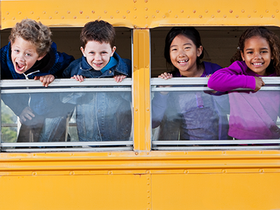 Children looking out school bus window