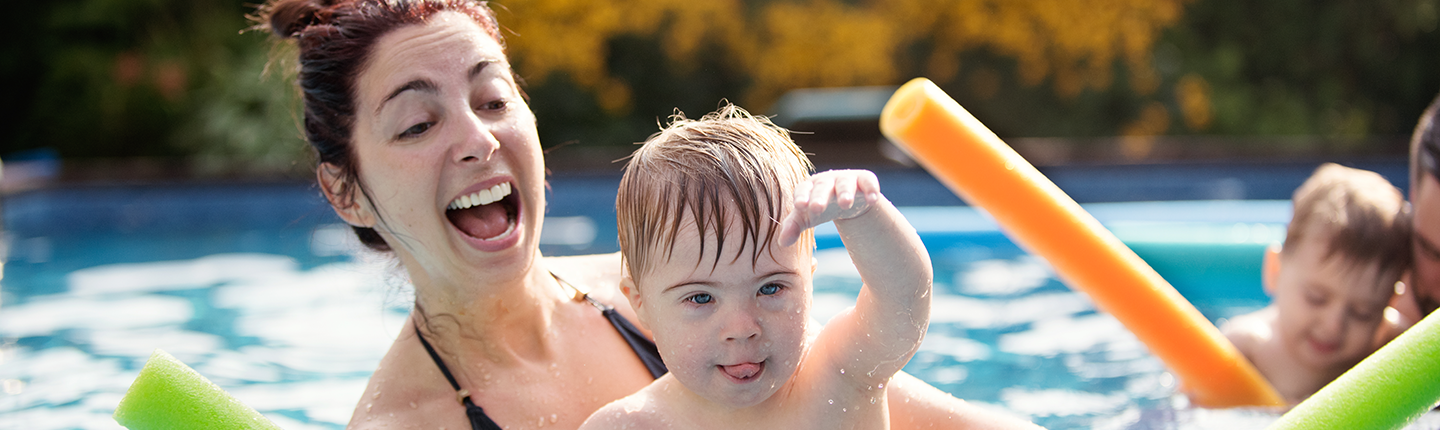 boy with Down syndrome having fun in the swimming pool