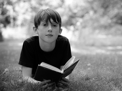boy reading a book outside