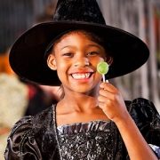 Little girl in halloween costume eating lollipop