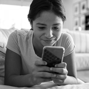 girl looking at smartphone on bed