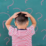 boy in front of board with question marks