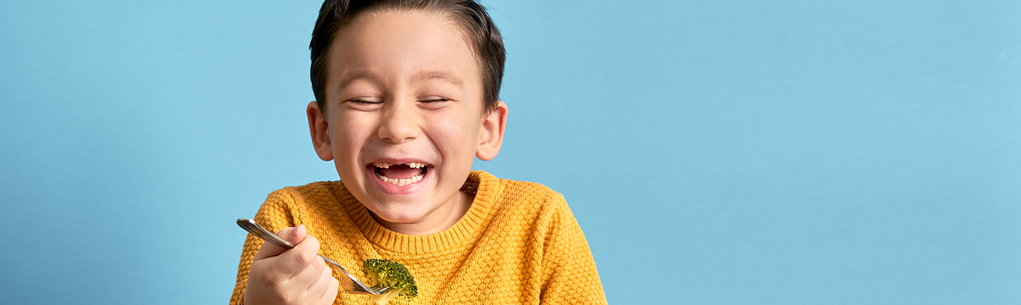 happy kid eating broccoli