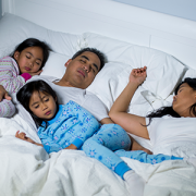 family sleeping in bed together