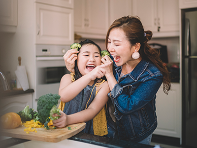 Mother and daughter laughing in kitchen