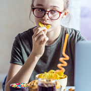 Girl working at a computer and eating fast food