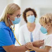doctor examining boy with face mask