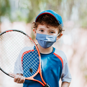 boy with tennis racket and face mask