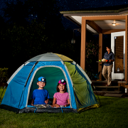 Children camping in a tent in the backyard