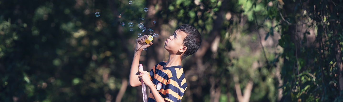 boy with autism blowing bubbles