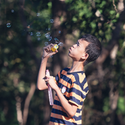boy with autism blowing bubbles